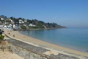 Enjoy a serene coastal scene with a sandy beach and scenic promenade.