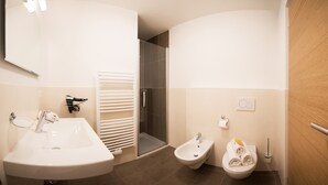 Un baño moderno con lavamanos, bidé y ducha.