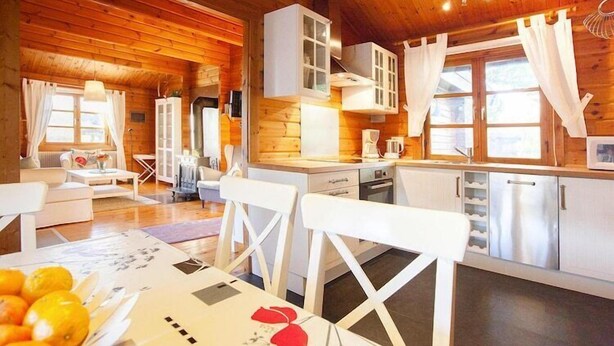 Een gezellig kamer in blokhutstijl met houten wanden en een kitchenette.