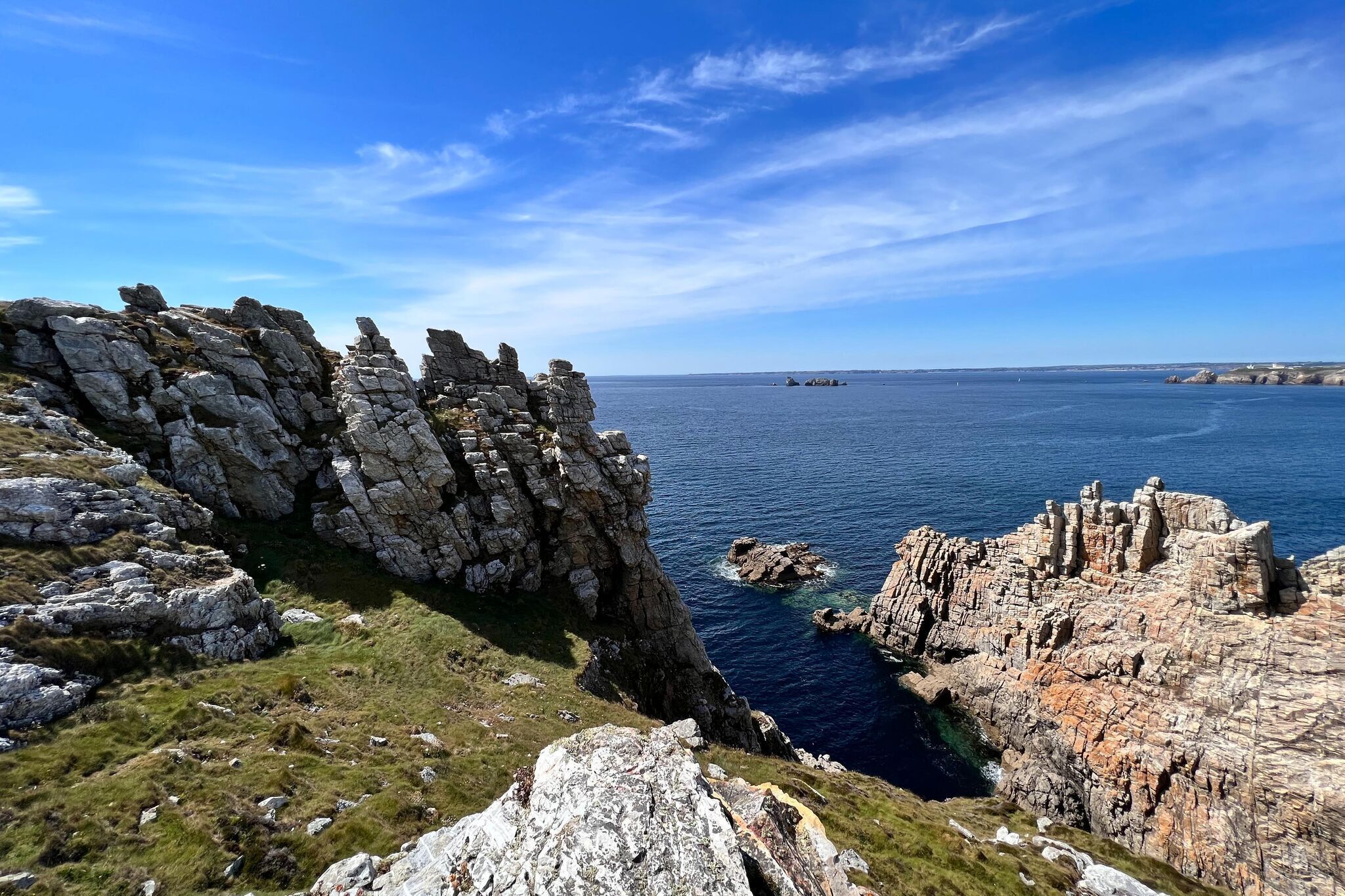 Eine Küstenlandschaft mit schroffen Klippen und freiem Blick auf das Meer.