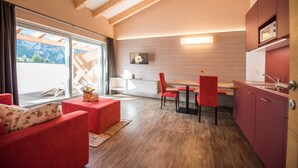 A modern interior with a dining area, kitchen, and seating with a view.