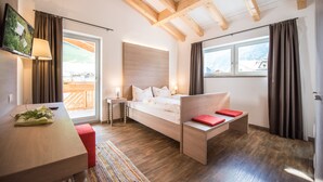 Une chambre à coucher avec un lit, une table de chevet et une vue sur l’extérieur.