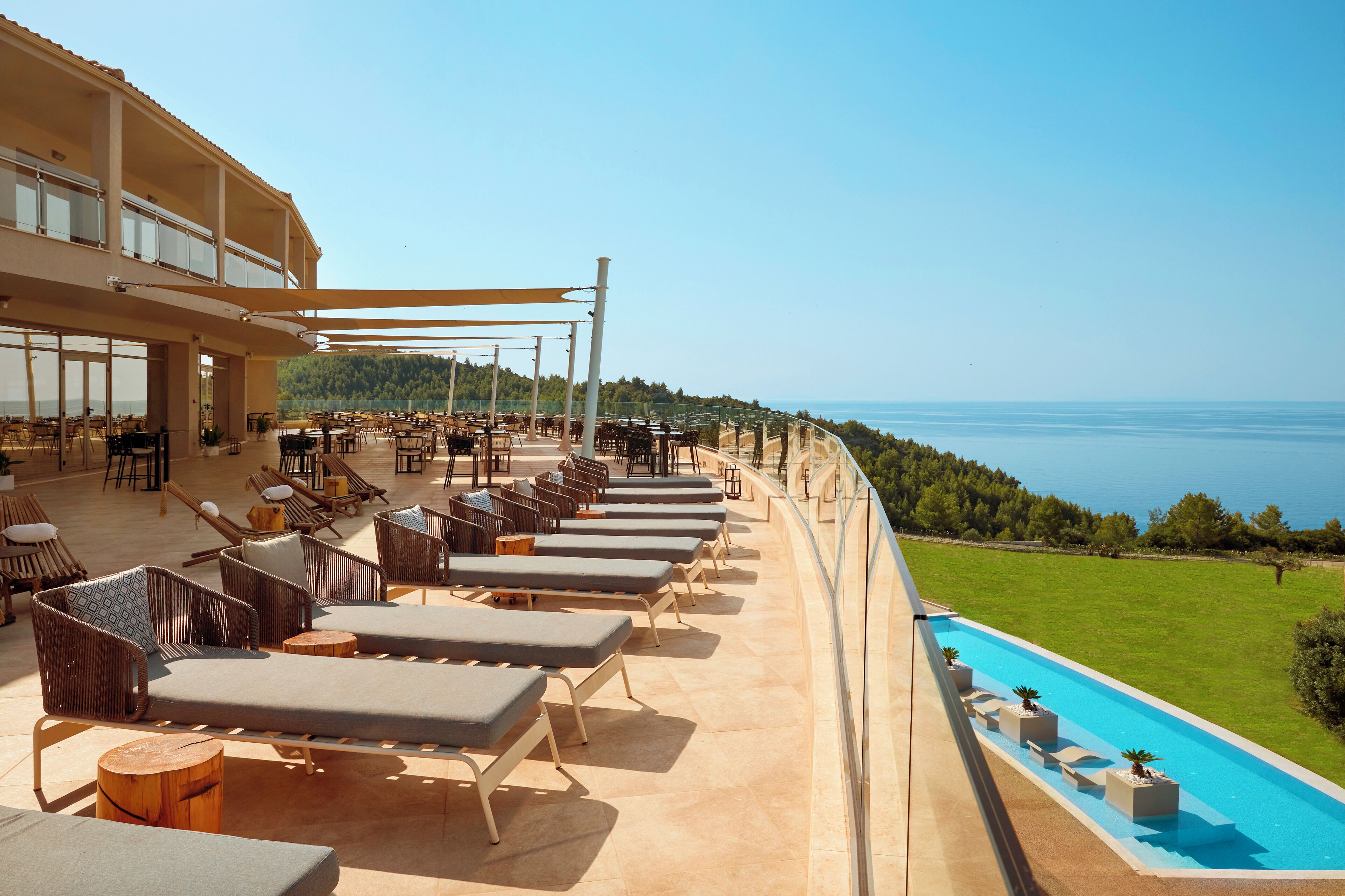 Terraza en la azotea con tumbonas, piscina y vistas al mar.