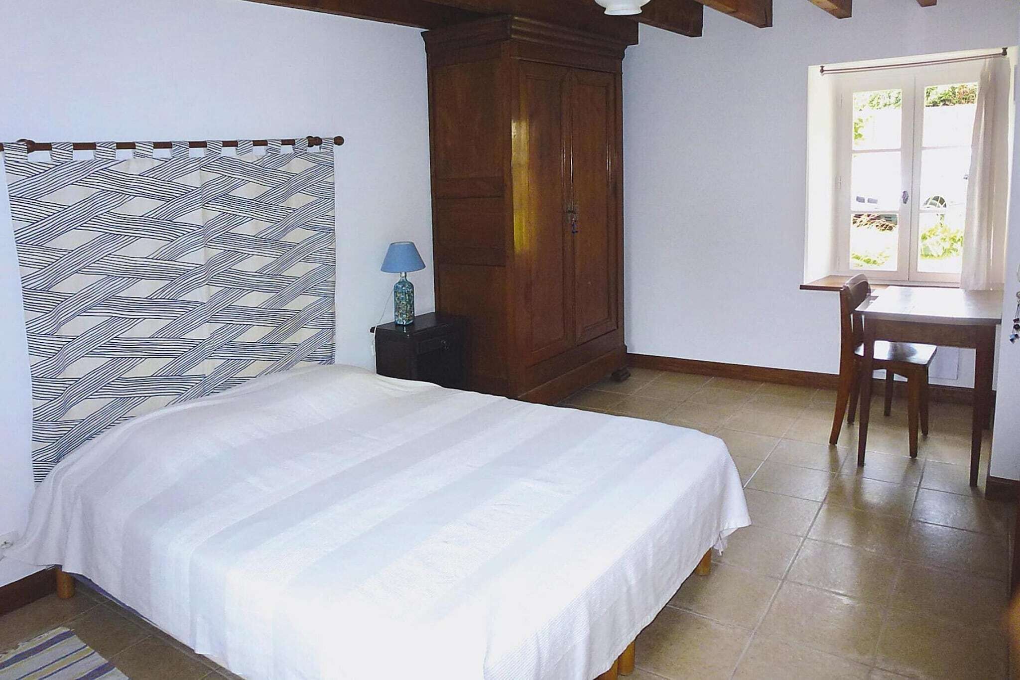 Une chambre à coucher avec un lit, un bureau et une fenêtre.