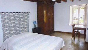 A bedroom with a bed, a desk, and a window. - Stone House in Plurien near Sandy Beaches (Plurien)