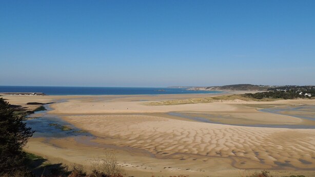 A wide sandy beach with gentle waves, a clear blue sky, and distant hills. - Stone House in Plurien near Sandy Beaches (Plurien)