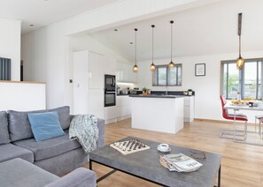A modern kitchen with white cabinetry, a central island, and pendant lighting.