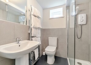Un baño moderno con lavabo, inodoro y ducha.