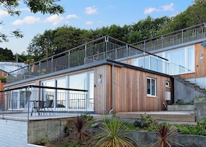 Un bâtiment moderne doté d’une façade en bois, de grandes fenêtres et d’un escalier en métal.