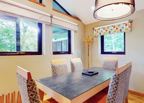A dining area with a table, chairs, and a ceiling light fixture.