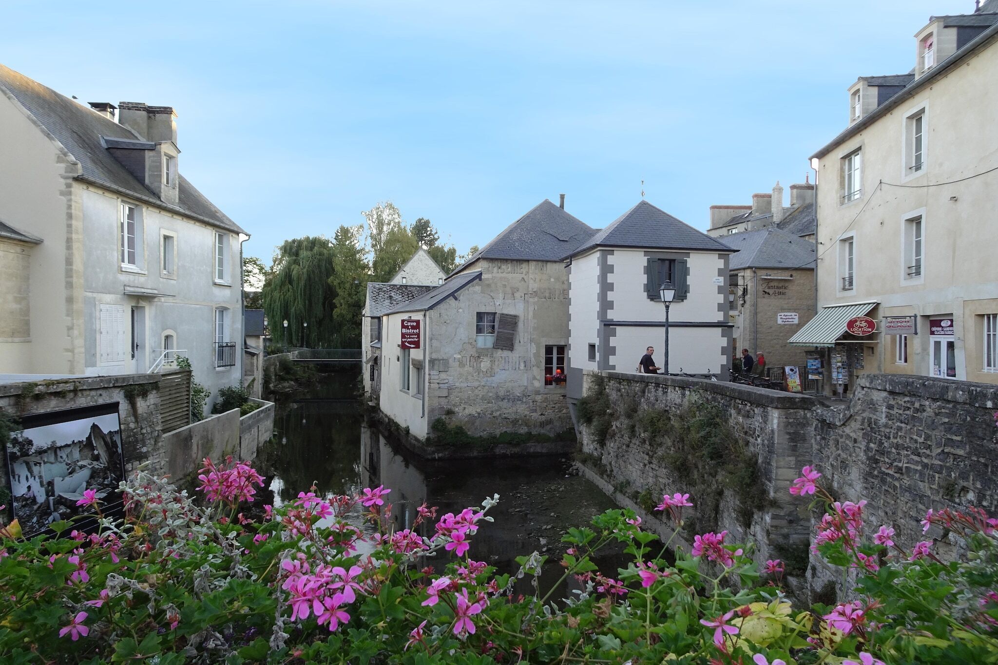 A narrow canal flanked by historic buildings with stone walls and traditional architecture.