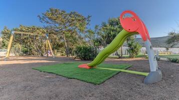A playground with a slide and swings.