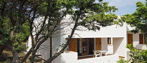 A modern white house with large windows and a patio area.