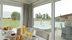 Een ontbijtsetting met een tafel, ontbijtartikelen en uitzicht op een jacuzzi.