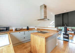 Uma cozinha moderna com bancada de madeira, eletrodomésticos embutidos e uma ilha grande.
