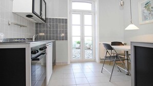 Eine kleine Küche mit Herd, Backofen und einem Essbereich mit Tisch und Stühlen.