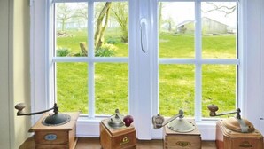 Una ventana con tres cajas de madera en un alféizar, cada una con un asa y un pomo.