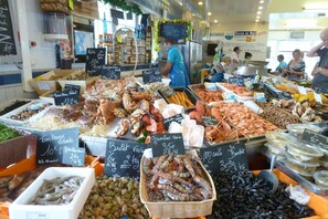 A seafood market with various seafood displayed on tables, including lobsters, crabs, and mussels. - Cottage in Normandy near Alabaster Coast (Crasville-la-Roquefort)