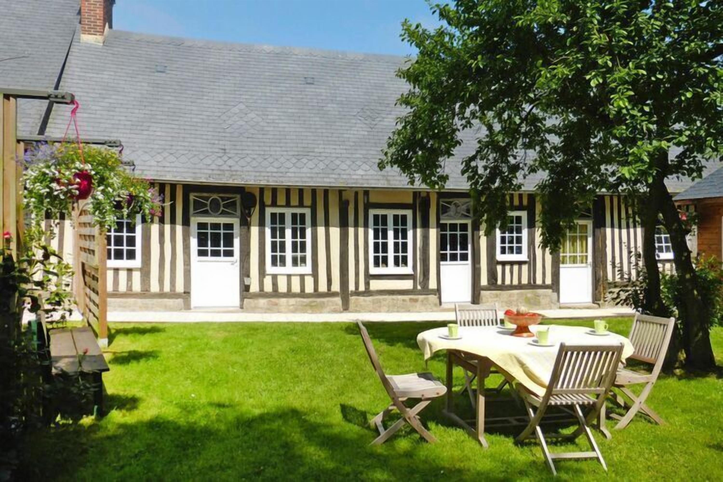 Il s’agit d’un bâtiment traditionnel à colombages doté d’un petit patio avec une table et des chaises.