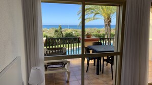 Et værelse med en stor skydedør, der fører ud til en balkon med pool og udendørs møbler.