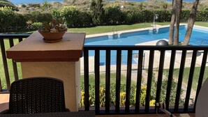 En balkon med havudsigt, en swimmingpool og en potteplante.
