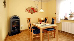 Un comedor con una mesa y sillas de madera, una chimenea y obras de arte en la pared.