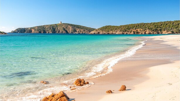 A beach with clear turquoise water, sandy shore, and rocky outcrops. - 1 bedroom cozy apartment in Pula (CA) (Pula (CA))