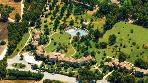 An aerial view of a resort with multiple buildings, a swimming pool, and surrounding greenery. - 1 bedroom cozy apartment in Pula (CA) (Pula (CA))