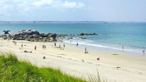 A beach with people, rocks, and a clear sky. - Fisherman's House in Brittany by the Sea (Plouescat)