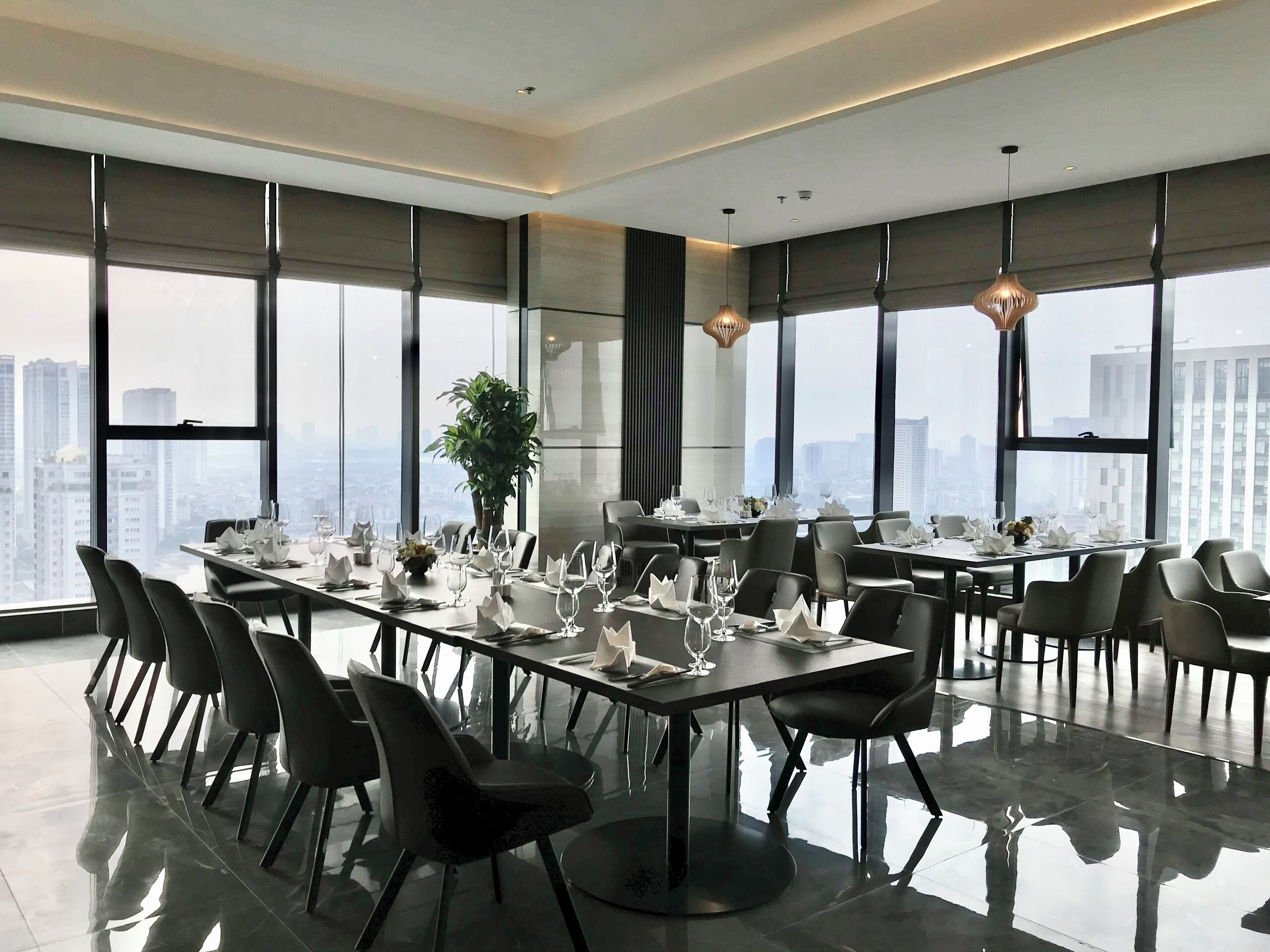 Una sala de conferencias moderna con ventanas amplias, suelo pulido y vistas a la ciudad.