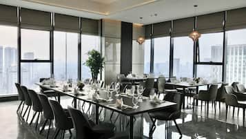 A modern conference room with large windows, a polished floor, and a city view.