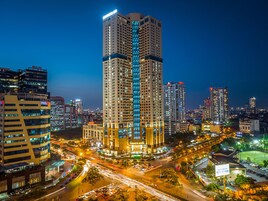 A high-rise hotel with multiple floors, a prominent entrance, and a well-lit facade.