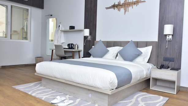 Una camera da letto moderna con un letto grande, comodini, una scrivania e uno specchio.
