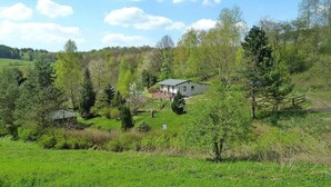 A house surrounded by greenery, with a clear sky and a distant hill. - Ferienhaus, Steinbach-Hallenberg (Steinbach-Hallenberg)