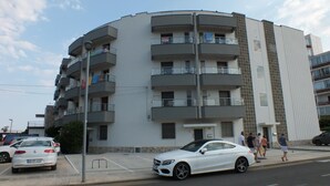 A multi-story residential building with balconies, a parking area, and a street view. - Beautiful renovated apartment for 4 with private parking in Roses (Roses)