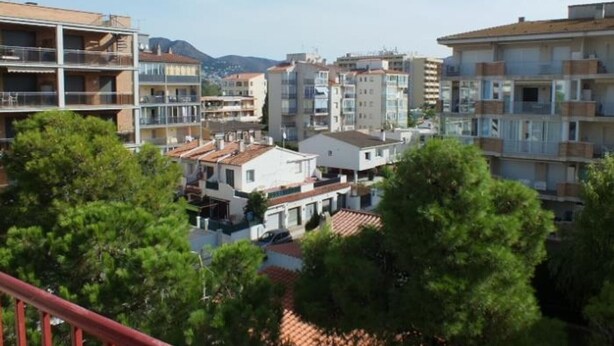 A residential area with multi-story buildings, some with balconies, and a mix of architectural styles.