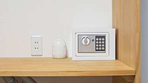 A white electrical outlet and a white device with a keypad on a wooden shelf. - HOME Tengachaya2F (Osaka)