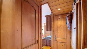 A wooden hallway with a door leading to a room.