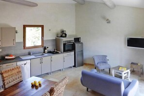 A modern kitchen with a window, built-in appliances, and a dining area with a table and chairs.