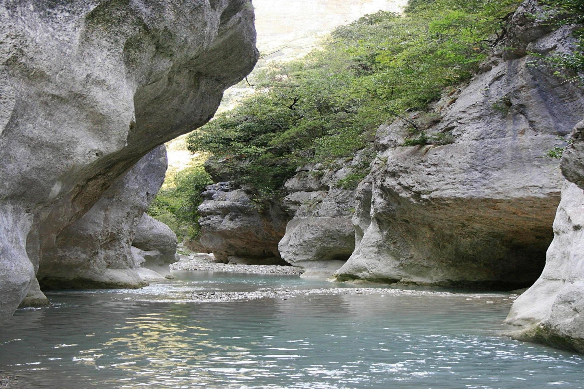 A natural rock formation with a river flowing through a canyon.