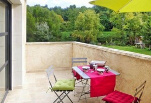 Enjoy a romantic meal for two on this balcony overlooking a serene landscape.