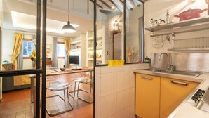 Une cuisine moderne dotée d’une grande fenêtre, d’un coin repas avec des chaises et d’un îlot central.