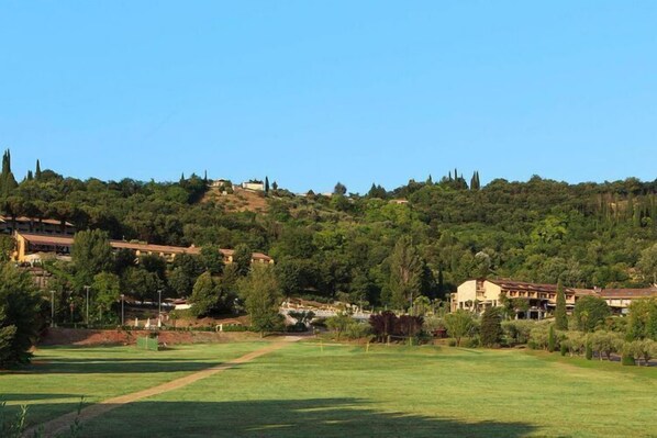 A golf course with a clear path, surrounded by buildings and trees. - Apartments Poiano in Garda with pool (Garda)