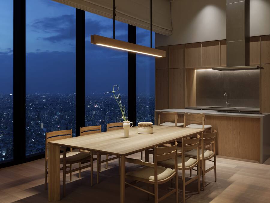 A modern kitchen with a large island, wooden cabinetry, and a city view through large windows.