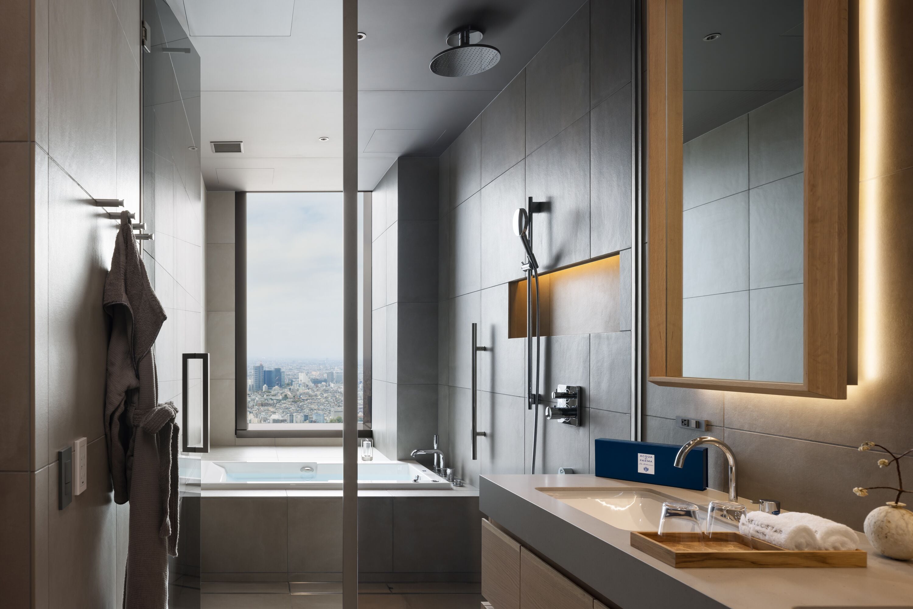 Ein modernes Badezimmer mit großem Fenster, einer Badewanne, einem Waschbecken und einem Spiegel.