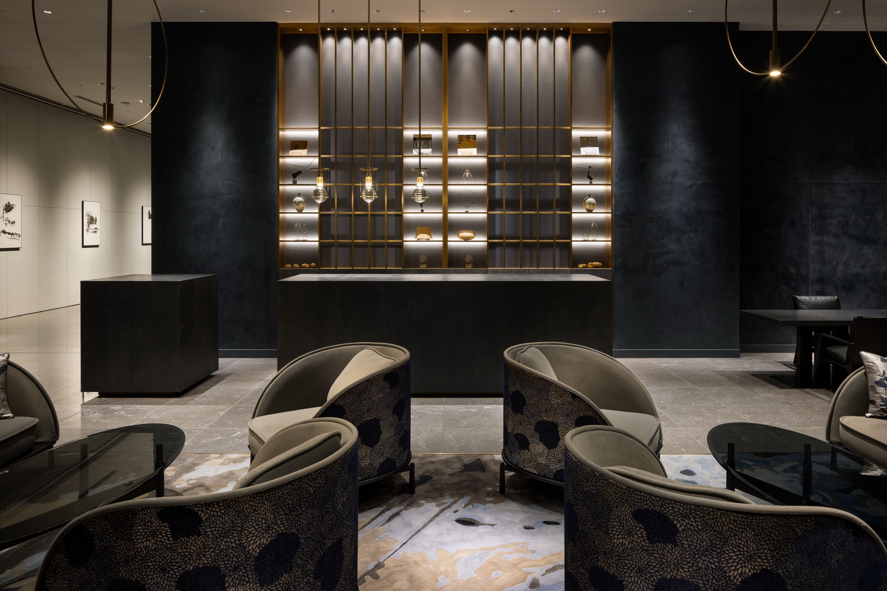 A modern lounge area with a central bar, seating, and a patterned floor.