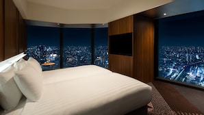 A modern hotel room with a large bed, a flat-screen TV, and a city view. - HOTEL GROOVE SHINJUKU, A PARKROYAL Hotel (Tokyo)