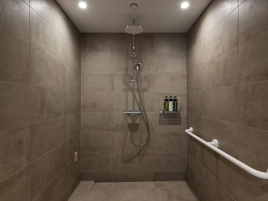 A modern shower with a handheld showerhead and a handheld shower attachment.