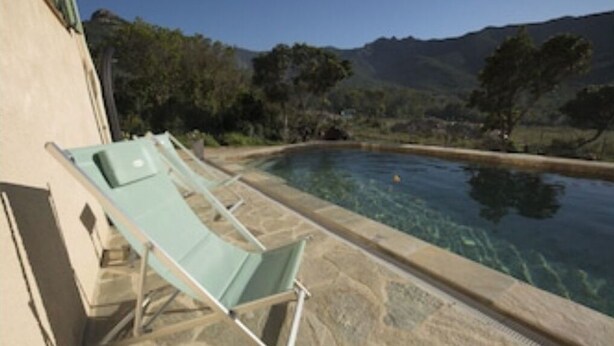 Area piscina con lettini e vista libera sul paesaggio circostante.