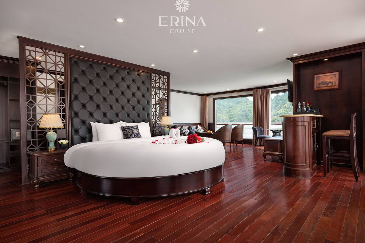 A luxurious bedroom with a large bed, a decorative headboard, and a view of the outdoors.